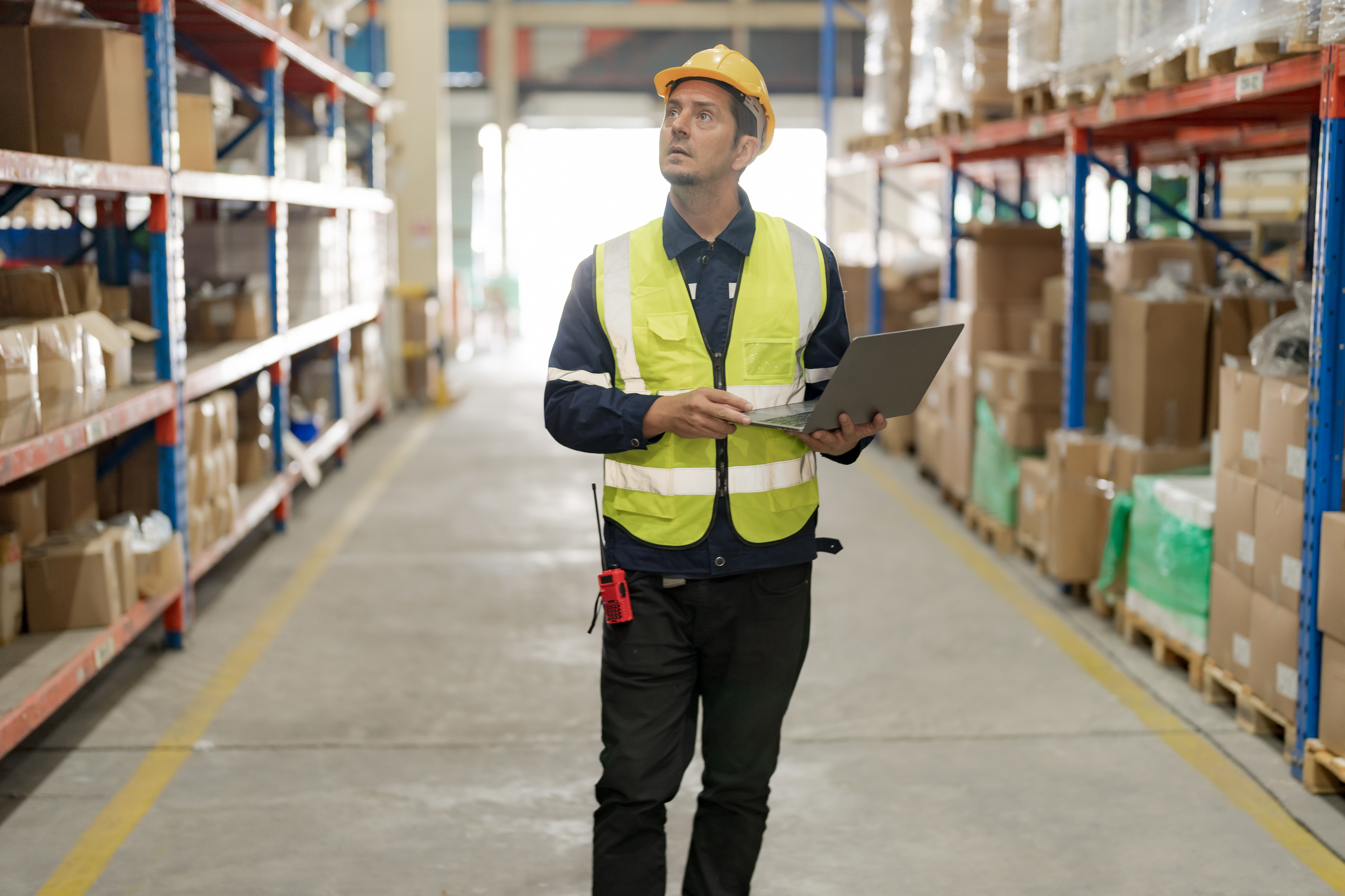 Male factory manager standing laptop.